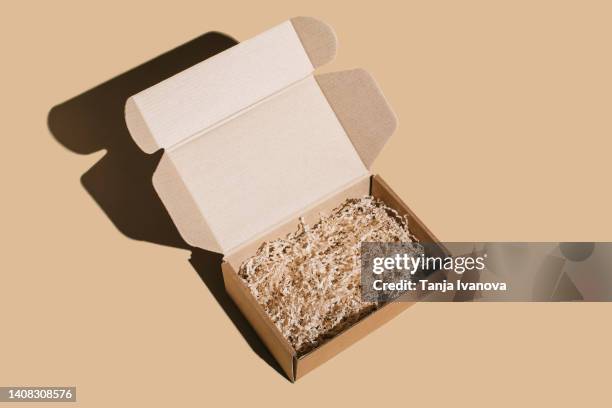 open blank brown cardboard box on beige background. - leere schachtel stock-fotos und bilder