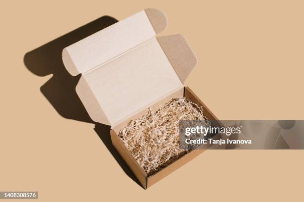 open blank brown cardboard box on beige background. - scatola foto e immagini stock