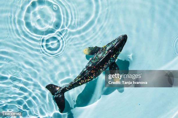 fish swim in the sea in microplastic. ocean plastic pollution, saving the environment concept. micro plastic in food and water or sea. - images of whale underwater stock pictures, royalty-free photos & images