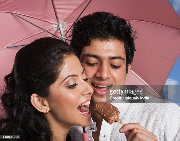 man feeding an ice cream to a woman - indian honeymoon couples stock pictures, royalty-free photos & images