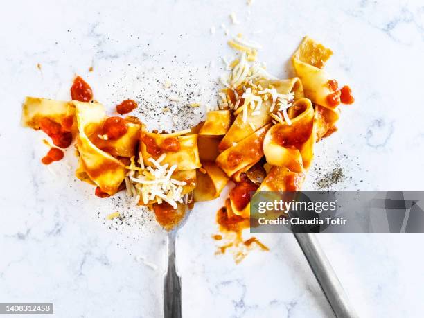 pasta with tomato sauce and shredded cheese on white background - sauce stockfoto's en -beelden