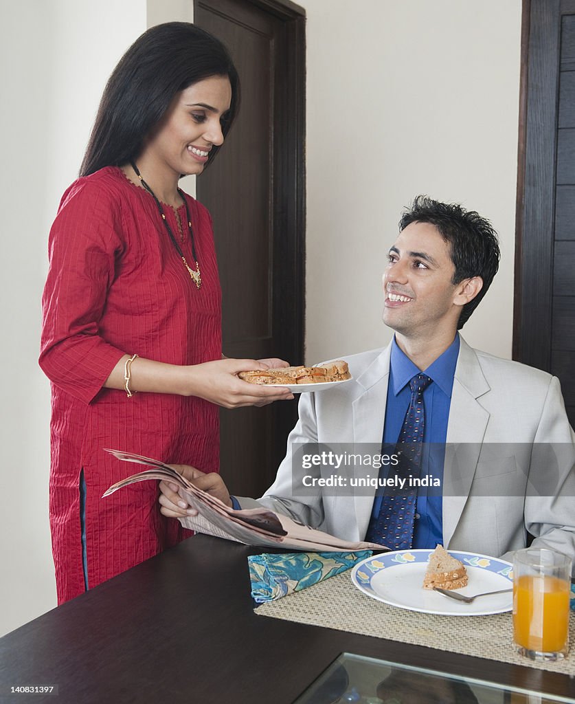 Woman serving breakfast to her husband