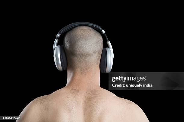 rear view of a man listening to headphones - shaved-buzz-cut-back-of-head photos et images de collection