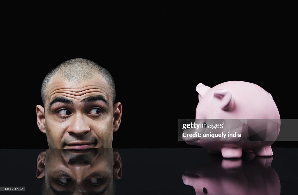 Businessman looking at a piggy bank