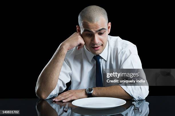 businessman sitting at a dining table and thinking - leaning on elbows stock pictures, royalty-free photos & images