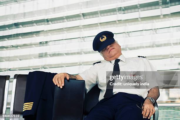 pilot resting on a bench at an airport - indian pilot stock-fotos und bilder