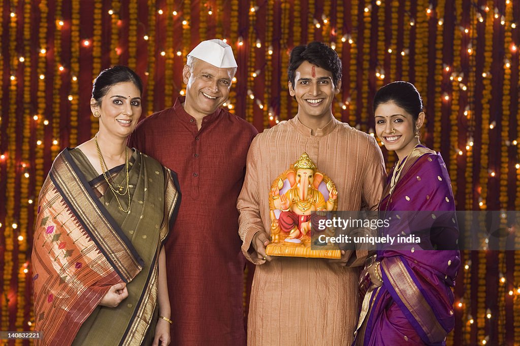 Portrait of a family holding an idol of lord Ganesha