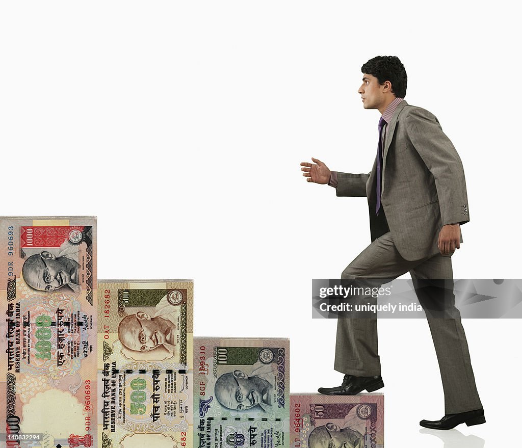 Businessman moving up on a staircase of money