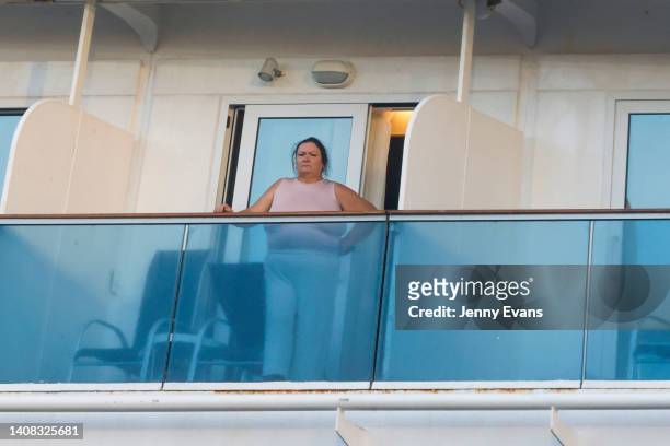 Woman looks on from her balcony on board the Coral Princess after it docked at Circular Quay on July 13, 2022 in Sydney, Australia. The Coral...