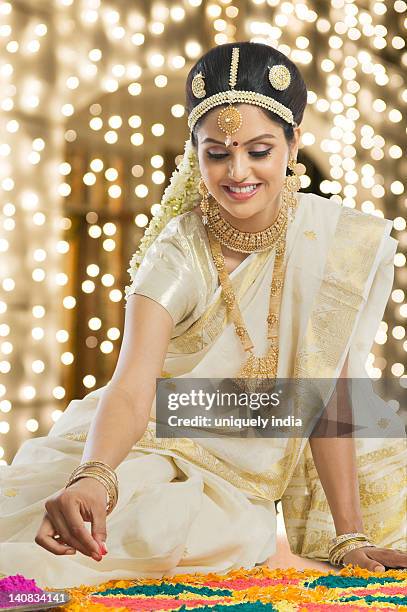 indian woman in traditional clothing making rangoli at durga festival - onam stock pictures, royalty-free photos & images