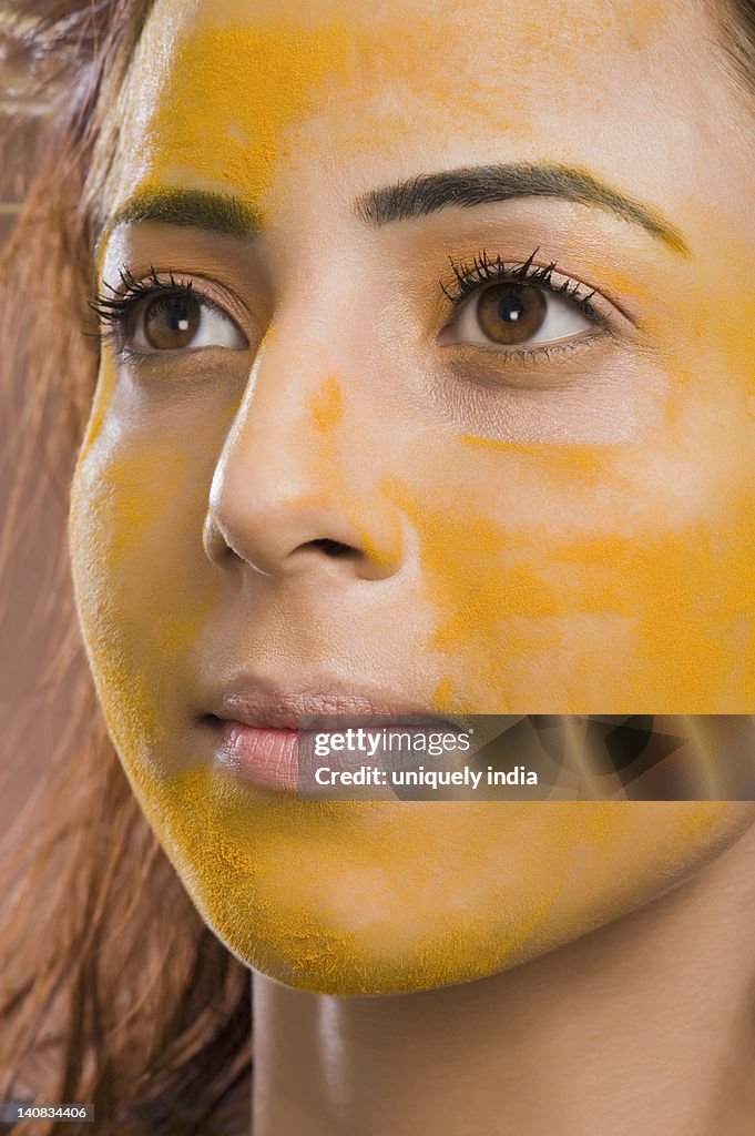 Close-up of a woman with turmeric on her face