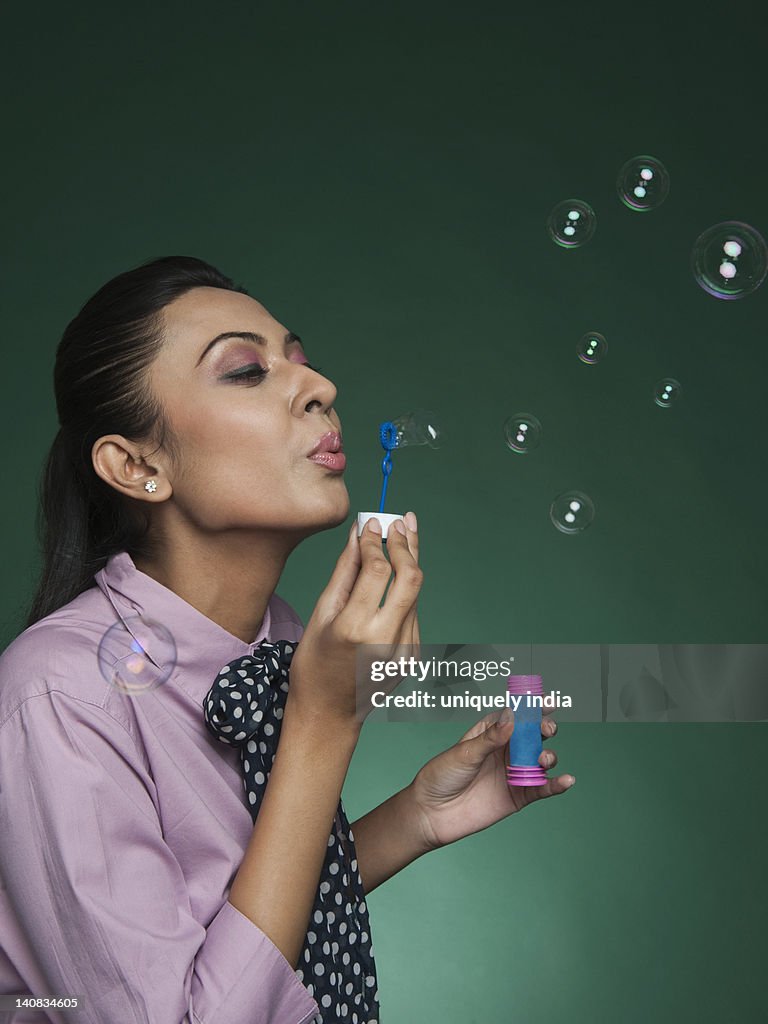 Businesswoman blowing bubbles with a bubble wand