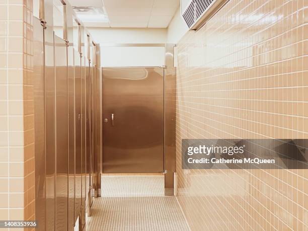 view of empty public bathroom corridor & stalls - public toilet bildbanksfoton och bilder