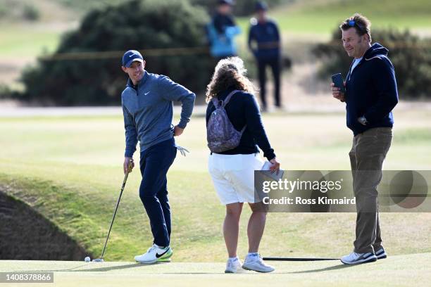 Sir Nick Faldo and Fanny Sunesson make their way around the course as they interact with Rory McIlroy of Northern Ireland during a practice round...