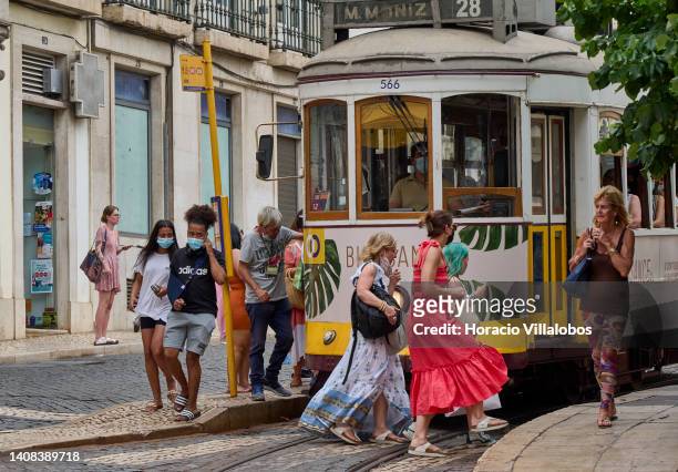 Tourists get off a Line 28 tram at Praça Camoes as temperature rises to 36º Celsius on July 12, 2022 in Lisbon, Portugal. High temperatures favor the...