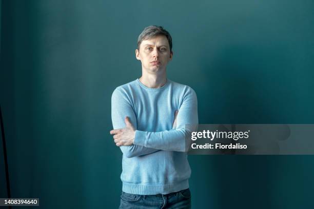 a middle-aged man against a blue wall - teal portrait stockfoto's en -beelden
