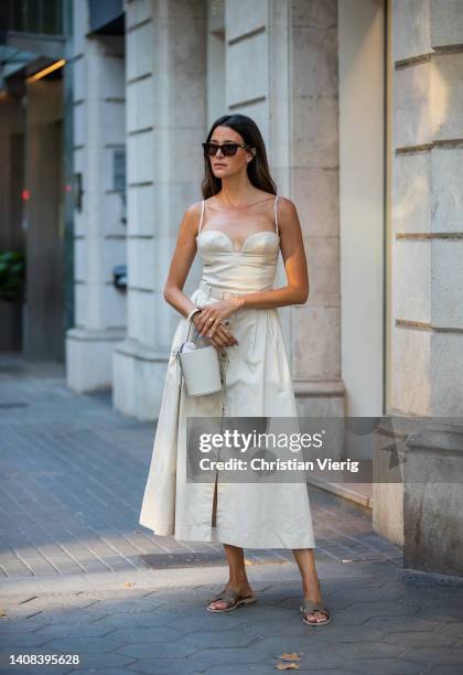 Paula Nata is seen wearing dress Carolina Herrera, bucket bag Adrianne, Hermes shoes on July 12, 2022 in Barcelona, Spain.