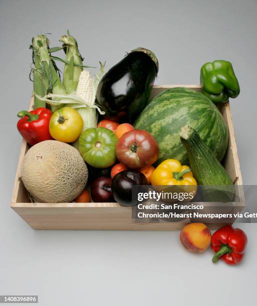 July20_fruitstilllife_039_pc.jpg Wooden fruit crate filled with assorted summer fruit -- small watermelon, canteloupe, corn, stone fruit, red and...
