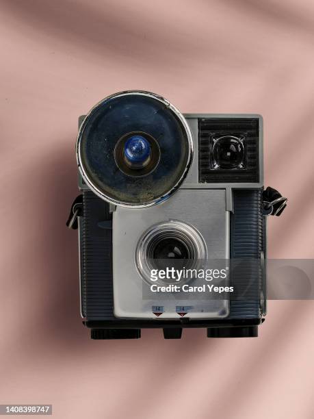 top view vintage photographic camera in pink surface casting shadows - film darchive photos stock pictures, royalty-free photos & images