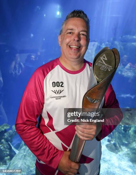 Baton bearer Darren Sims holds the Queen's Baton during the Birmingham 2022 Queen's Baton Relay on a visit to The Deep, Hull, United Kingdom on July...