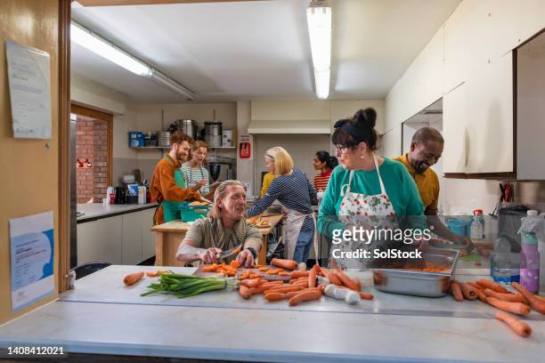chopping the carrots together - arm made of vegetables stockfoto's en -beelden