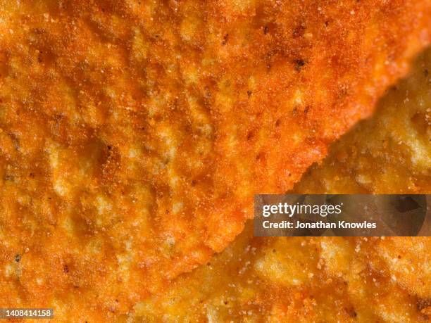 macro shot orange corn chip - salzige zwischenmahlzeit stock-fotos und bilder