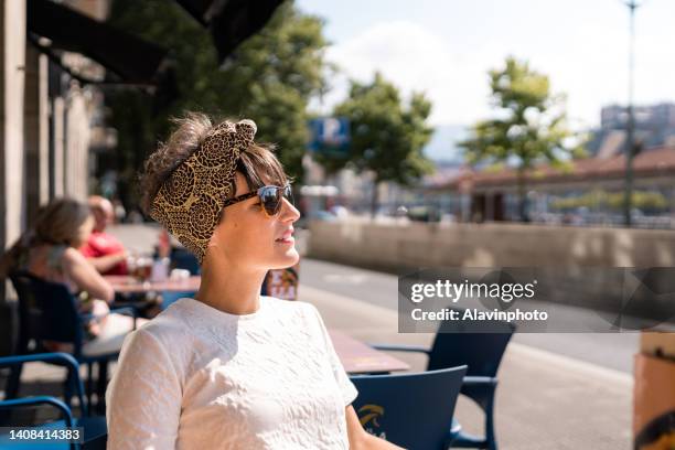 woman sunbathing on a bar terrace - bilbao spain photos et images de collection