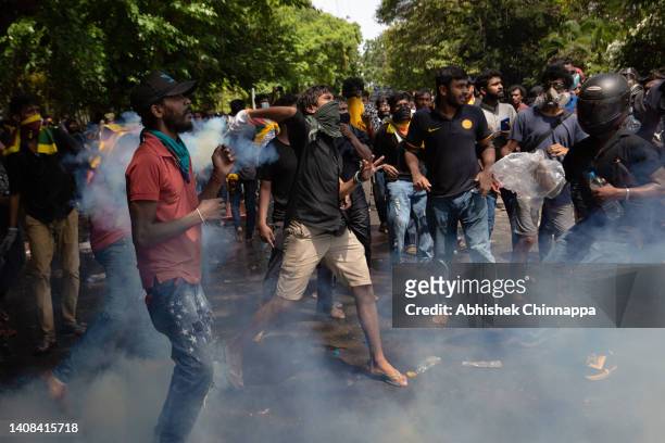 Protestor throws back a tear gas canister fired by army personnel during a protest seeking the ouster of Sri Lanka's Prime Minister Ranil...