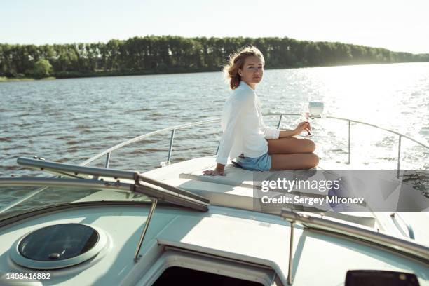 woman lying down on deck with champagne and taking sunbath - sail boat deck stock pictures, royalty-free photos & images