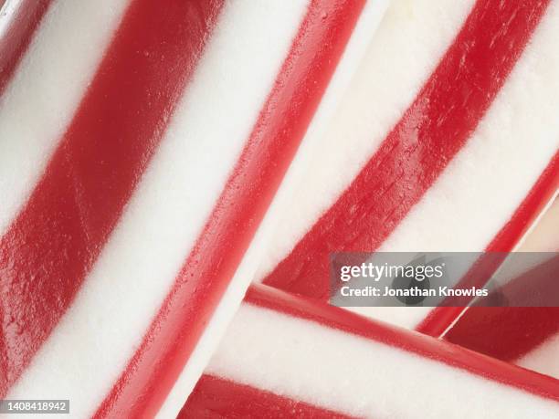 extreme close up red and white striped candy - zuckerstange stock-fotos und bilder