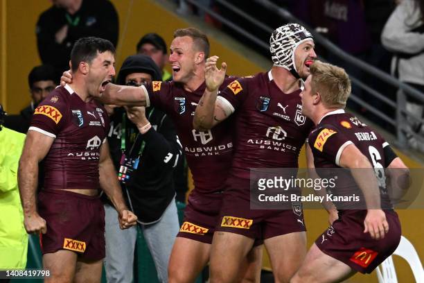 Ben Hunt of the Maroons celebrates with teammates after scoring the match winning try during game three of the State of Origin Series between the...