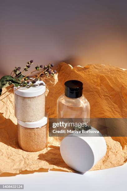 two jars of scrub and shower gel or shampoo on a yellow-brown background. - bath salt stock pictures, royalty-free photos & images