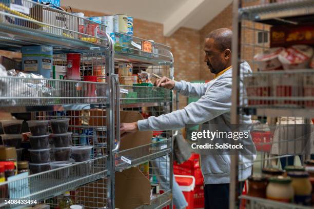 sorting through the food storage - foodbanks for the needy stock pictures, royalty-free photos & images