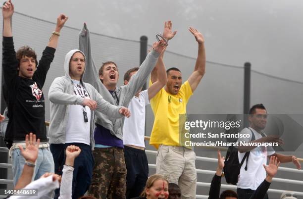 Players from the Academy of Art men's soccer team, including Jamie Patino, lower right, celebrate a goal by the women's team in San Bruno, Calif., on...