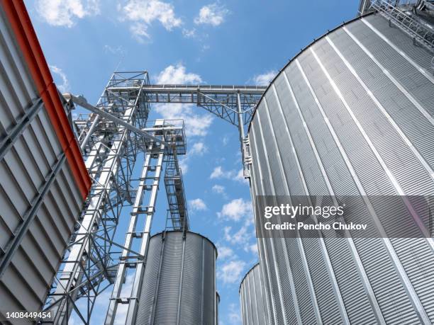 close up view of huge, shining agricultural grain silos. agricultural occupation. global business. investment in agriculture. - edificio agrícola fotografías e imágenes de stock