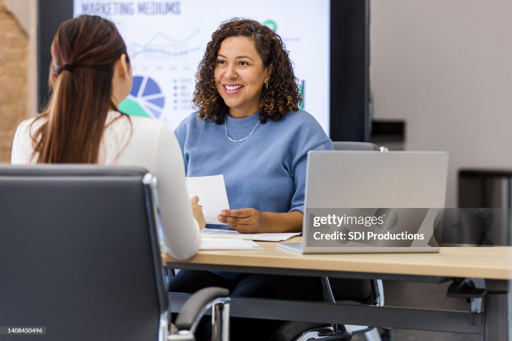 Female manager meets with unrecognizable employee for performance review
