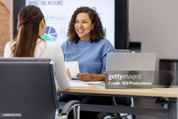 female manager meets with unrecognizable employee for performance review - employee review imagens e fotografias de stock