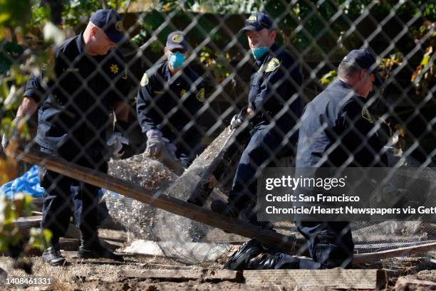 Authorities from the Alameda County Sheriff's Department demolish a chicken coop while searching for evidence in the backyard of a next door neighbor...