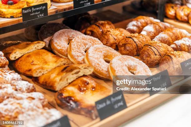 fresh sweet pastry on a display in bakery - bakery imagens e fotografias de stock