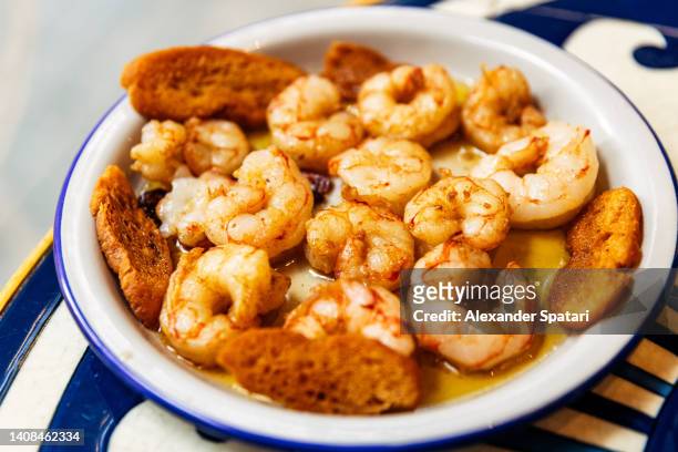 shrimps in garlic sauce in a tapas bar in barcelona, spain - prawn stock-fotos und bilder
