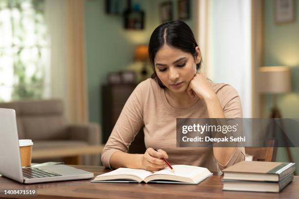 student typing in a laptop in her room, stock photo - centralization stockfoto's en -beelden