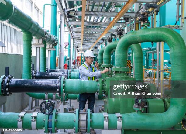 asian male engineer working at factory with pipeline and pump. - águas residuais imagens e fotografias de stock
