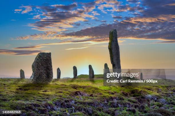 scenic view of rocks on field against sky during sunset,stromness,united kingdom,uk - stone circle stock-fotos und bilder