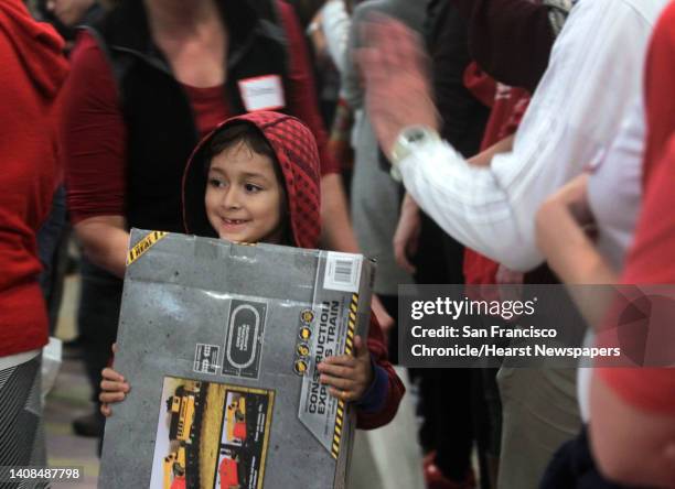 Nick Gonzalez clutches a new electric train set at the annual holiday toy giveaway for children at Glide Memorial Church in San Francisco, Calif. On...