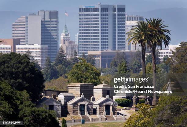 The downtown skyline rises behind mausoleums at Mountain View Cemetery in Oakland, Calif. On Friday, June 19, 2015. The resting place for over...