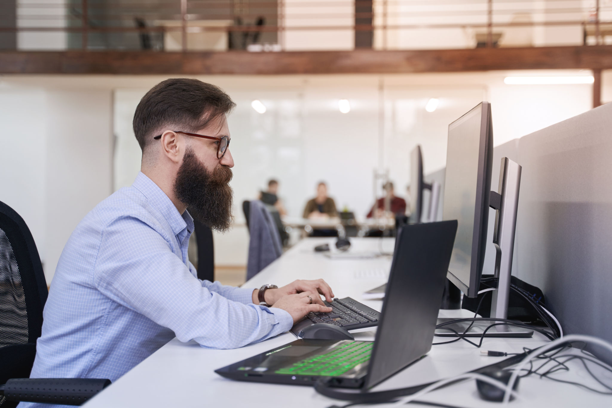 Senior computer programmer developer working in IT office, sitting at desk and coding, working on a project in software development company or startup Senior computer programmer developer working in IT office, sitting at desk and coding, working on a project in software development company or startup