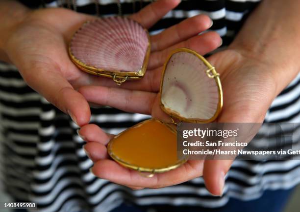 Retail manager Madeline Garfolo displays solid perfume packaged in a sea shell compact at Earthship in Oakland, Calif. On Saturday, Sept. 5, 2015.