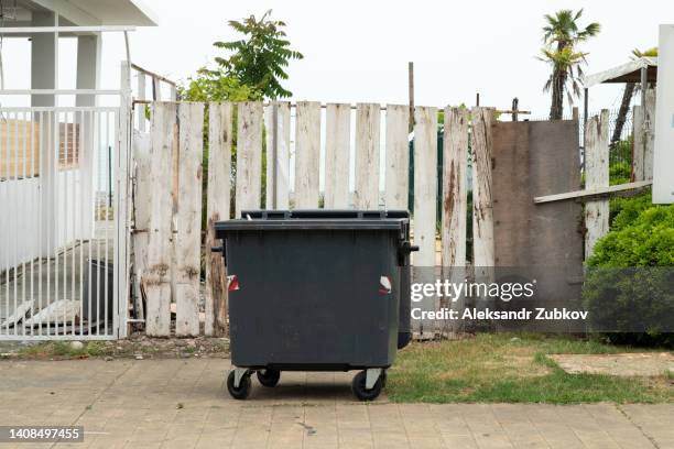 plastic trash can or dumpster, a tank on wheels for moving and transporting, outdoors. the concept of environmental protection, sustainable lifestyle. recycling of garbage. - müllcontainer stock-fotos und bilder