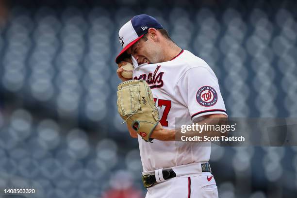 Cory Abbott of the Washington Nationals wipes his face after giving up a home run to Cal Raleigh of the Seattle Mariners during the ninth inning of...