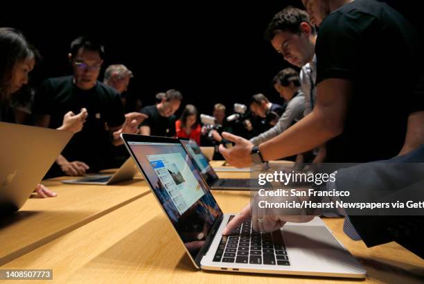 Guests try out the Touch Bar on the updated version of the MacBook Pro laptop at Apple headquarters in Cupertino, Calif. On Thursday, Oct. 27, 2016.